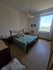 a bedroom with a bed and a large window at Il Paradiso di Adriana in Bonassola