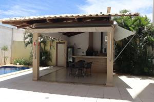 a pavilion with a table and chairs next to a pool at Vista Panorâmica • Premium in Palmas