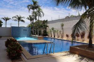 a swimming pool with palm trees next to a building at Vista Panorâmica • Premium in Palmas