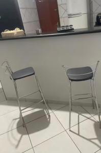 a chair sitting next to a counter in a kitchen at Sua casa longe de casa in Anápolis +1 photo