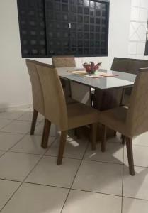 a dining room table and chairs with a white floor at Sua casa longe de casa in Anápolis