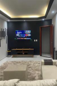 a living room with a couch and a flat screen tv at Sua casa longe de casa in Anápolis
