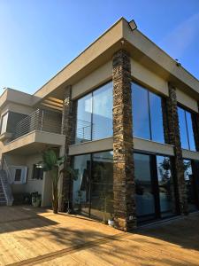 a house with large glass windows on a deck at נוף המצוק בגליל in Even Menahem