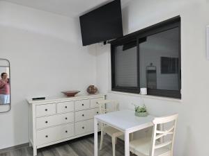 a dining room with a dresser and a white table and chairs at נוף המצוק בגליל in Even Menahem