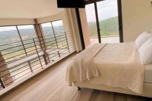 a bedroom with a bed and a large window at נוף המצוק בגליל in Even Menahem +19 photos