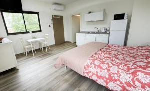 a bedroom with a bed and a kitchen and a table at נוף המצוק בגליל in Even Menahem