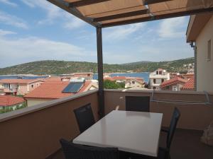 a table and chairs on a balcony with a view at Apartmani Blažević in Zaglavice