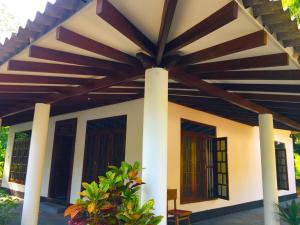 a house with a large wooden roof at Dil villa in Habaraduwa Central