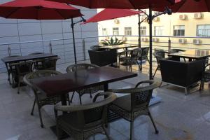 a patio with tables and chairs and umbrellas at New Cozy Harbour Hotel in Nanning