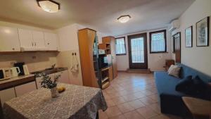 a kitchen and living room with a table and a blue couch at Apartment Viola - Pavićini, Duga Uvala in Krnica +4 photos