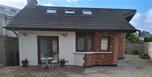 a small white house with a table and chairs at Sea Loft in Shankill