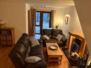 a living room with a leather couch and a table at Sea Loft in Shankill