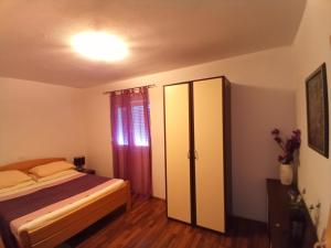 a bedroom with a bed and a cabinet in it at Apartmani Blažević in Zaglavice