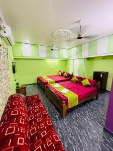 a bedroom with two beds and two chairs at Eden Villa in Virāmpattinam