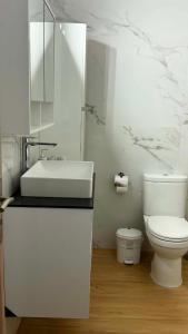 a white bathroom with a sink and a toilet at Markella STONE & LIGHT Skoutari-Mani in Skoutari +32 photos