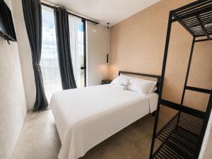 a bedroom with a white bed and a bunk bed at Casa Rosa in Aguascalientes