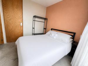 a bedroom with a bed with white sheets and a mirror at Casa Rosa in Aguascalientes +21 photos
