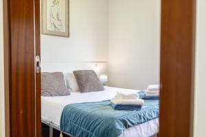 a bedroom with a bed with towels on it at Luz's Retreat Apartment in Ponta Delgada