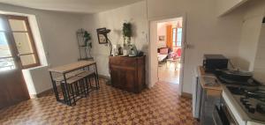a kitchen with a counter and a table in a room at Gite des pecheurs, Gorges du Tarn in Mostuéjouls +6 photos