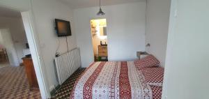 a bedroom with a bed and a tv on the wall at Gite des pecheurs, Gorges du Tarn in Mostuéjouls