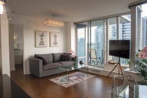 a living room with a couch and a tv at Gorgeous Unit with City Views in Vancouver