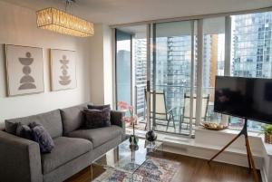 a living room with a couch and a large window at Gorgeous Unit with City Views in Vancouver
