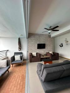 a living room with couches and a ceiling fan at Casa Paraíso in San Jerónimo