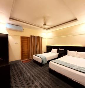 a hotel room with two beds and a window at Jolpoddo Retreat in Sreemangal