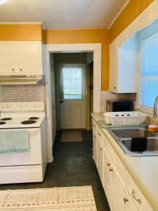 a kitchen with white cabinets and a white stove top oven at The Humble House in Martinsville +25 photos