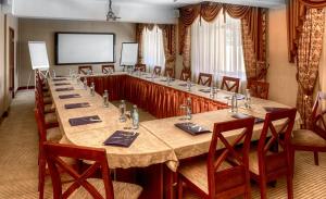 een grote vergaderzaal met een lange tafel en stoelen bij Voyage Hotel in Alma-Ata