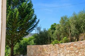 a stone wall with trees and a tree behind it at Villa Shelegar in (( Metoq ))