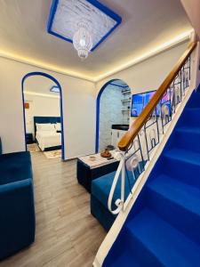 a room with a staircase and a living room at Casa Inass blue in Chefchaouen