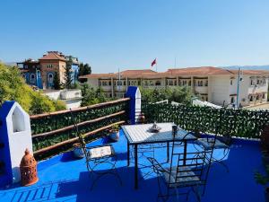a patio with a table and chairs on a balcony at Casa Inass blue in Chefchaouen