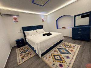 a bedroom with a large bed and a rug at Casa Inass blue in Chefchaouen