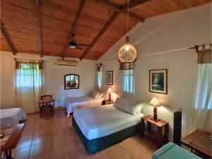 ein Schlafzimmer mit zwei Betten und einer Couch in der Unterkunft Kakao Lodge & Garden Río Celeste in Bijagua