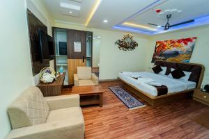 a bedroom with a bed and a living room at Ravila Grand Hotel in Lingampalli