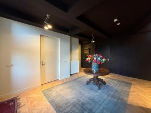 a room with a table with a vase of flowers on it at Logement Langestreek in Lemmer +1 photo