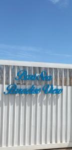 a white fence with a sign on the beach at Bari Sea Paradise View in Bari