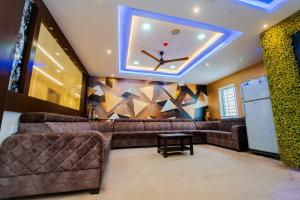 a living room with a couch and a ceiling at Ravila Grand Hotel in Lingampalli