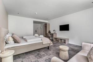 ein weißes Schlafzimmer mit Bett und Fernseher in der Unterkunft Hotel Kongens Ege in Randers