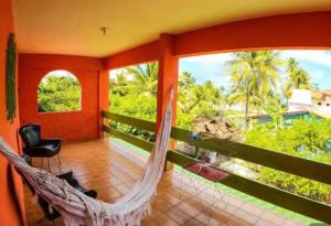 a room with a hammock on a balcony with a view at Suites Mar a Vista in Porto De Galinhas