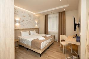 a hotel room with a bed and a table and a desk at Leomare in Odesa