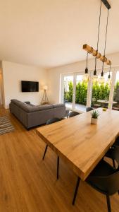 a living room with a wooden table and a couch at Allgäu Ferienhaus 5 Apartments mit Sauna,Balkon, Garten und Privatparkplatz in Blaichach