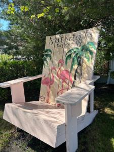 a white bench with a painting on the back of it at Saltwater Inn in Belmar