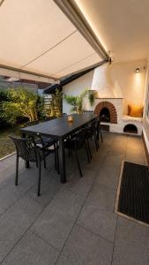 a black table and chairs on a patio with a fireplace at Allgäu Ferienhaus 5 Apartments mit Sauna,Balkon, Garten und Privatparkplatz in Blaichach