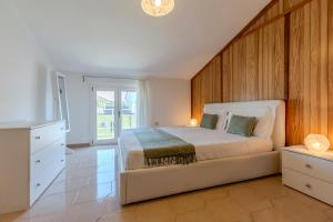 a bedroom with a bed with a wooden wall at Family friendly apartment in Giba Center in Giba