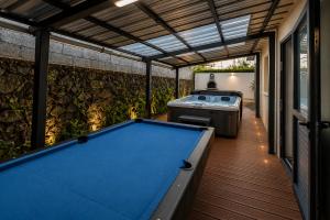 a pool table in a backyard with a grill at La Kaz Beaufond - Jacuzzi - T4 climatisée & familiale in Saint-Benoît