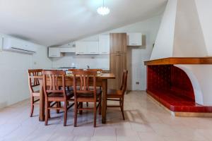 a kitchen with a table and chairs and a fireplace at Family friendly apartment in Giba Center in Giba +12 photos