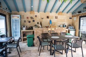 a restaurant with tables and chairs and a kitchen at VAMA 25- Vama Veche in Vama Veche