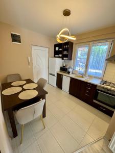 a kitchen with a table and a dining room at Ditta Home in Nyíregyháza